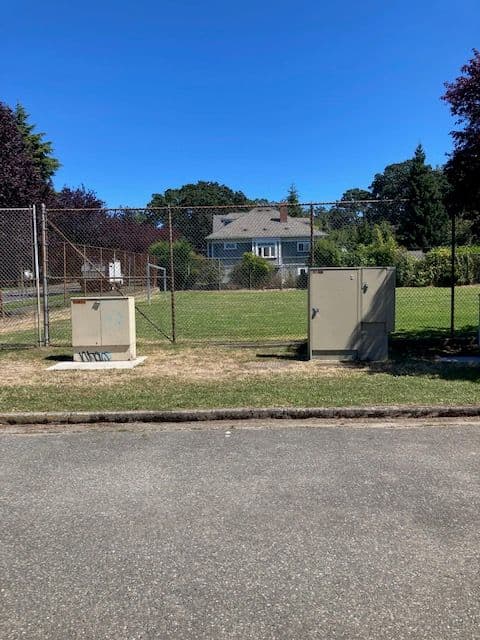 Two unwrapped utility cabinets beside a public field